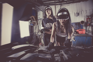 Fototapeta na wymiar Women mechanics are inspecting the engine at the service station.