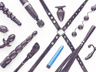 Wet sex toys with drops of water on them are on a white background. The image is suitable for sex shop advertising