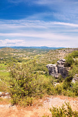 Fototapeta na wymiar Beautiful view from the mountain to the river valley with fields, meadows, roads, white fluffy clouds and blue sky. South France, Europe