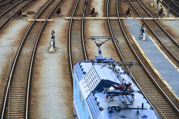 Electric locomotive and a train standing on the railroad tracks