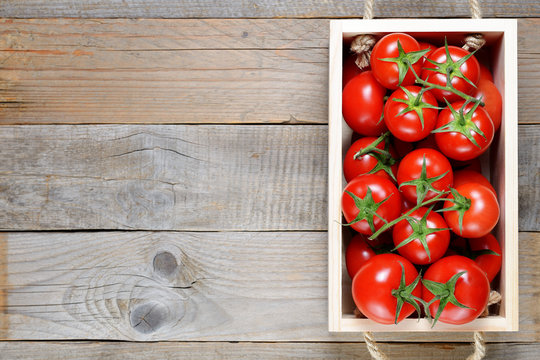 Tomatoes in box on wooden table