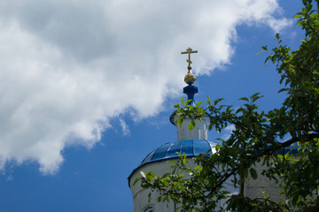 Fototapeta na wymiar View on golden cross and Russian orthodox church on blue sky and clouds background