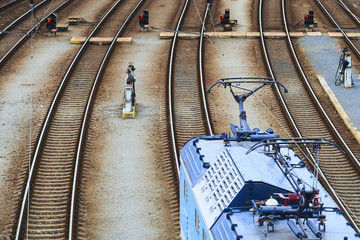 Electric locomotive and a train standing on the railroad tracks
