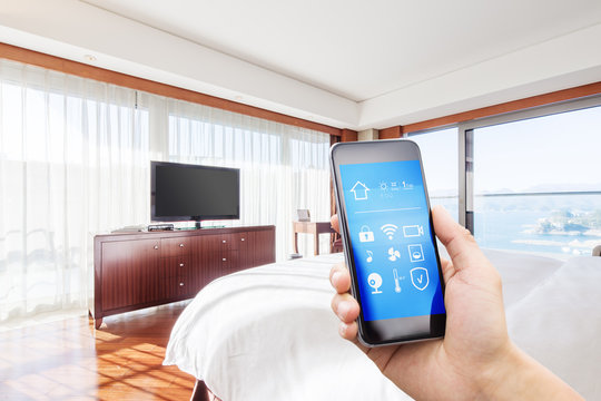 mobile phone with smart home app in modern bed room