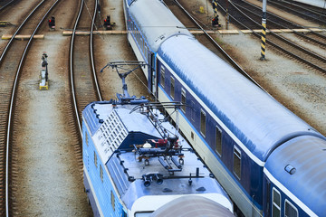 Electric locomotive and a train standing on the railroad tracks