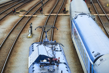 Electric locomotive and a train standing on the railroad tracks