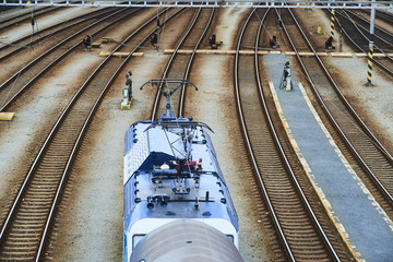 Electric locomotive and a train standing on the railroad tracks
