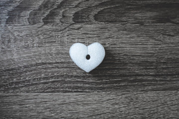 White foam heart on wooden surface