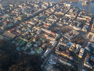Obraz premium The panoramic bird's eye view from drone to the central historical part of the city Kiev - the Podol district, the Dnieper River in Kiev, Ukraine at summer sunset.