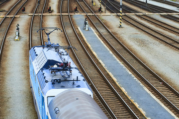 Electric locomotive and a train standing on the railroad tracks
