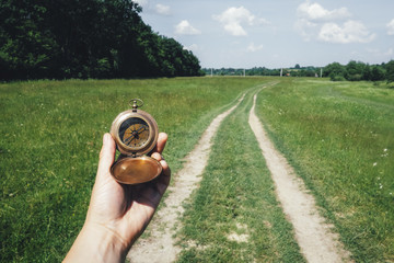 Man with compass in hand on rural road. Travel concept © Ivan Kmit