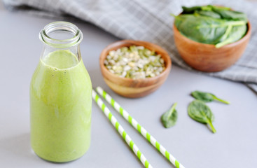 Green spinach smoothies in jar with seeds and nuts, healthy food concept