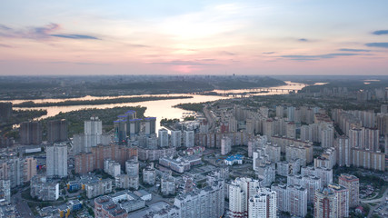 A bird's eye view, aerial panoramic view from drone to the Darnyts'kyi district of Kiev, Ukraine and view to the right bank of Dnieper at sunset in the summer.