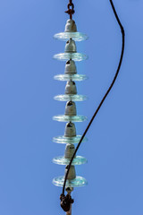 Electrical insulators made of hardened glass, top view, blue background, vertical photo.