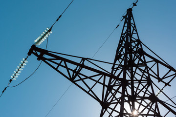 Top of power line tower, glass insulators, clear sky, high contrast