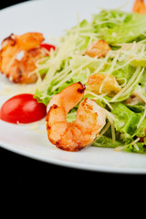 Seafood caesar salad with shrimps, salad leaf, cherry tomato and parmesan cheese.