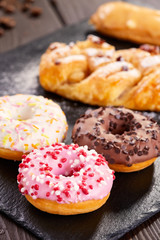 Assorted donuts with pink glazed, chocolate frosted and sprinkles