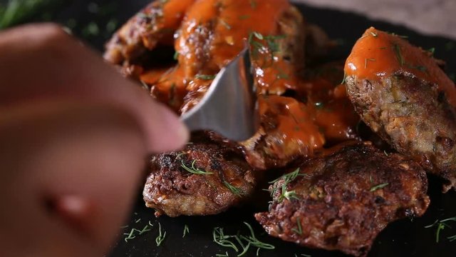 Eating fresh pork and beef meatballs with tomato sauce and dill
