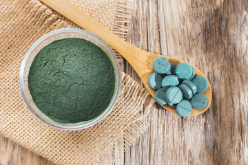 seaweed powder spirulina on wooden background