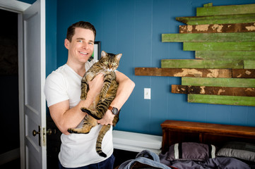 Young man holding cat 