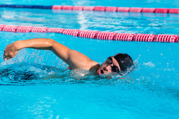 Swimmer man sport training at swimming pool. Professional male athlete doing crawl freestyle stroke...