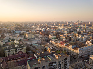The panoramic bird's eye view from drone to the central historical part of the city Kiev - the Podol district, the Dnieper River in Kiev, Ukraine at summer sunset.