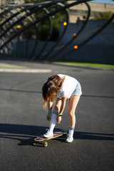 Girl in white stockings riding on longboard