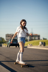 Obraz premium Girl in white stockings riding on longboard