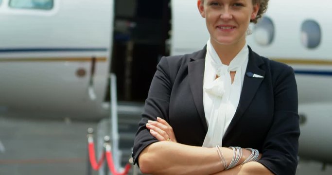 Flight attendant standing with arms crossed on a runway 4k