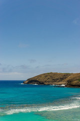 Tropical coastline and corals bay with turquoise water on a sunny day