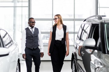 Dealership managers go between two cars talking to each other