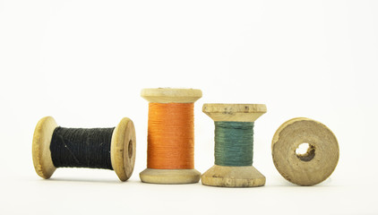 Reel or wood spool of sewing thread isolated on white.