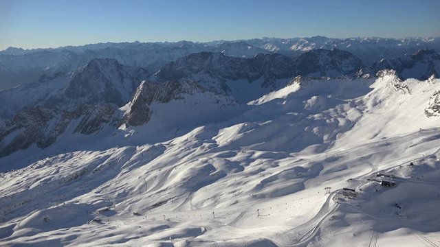 The alpine panorama seen from the summit of Germany's tallest mountain, the Zugspitze, looking southwest including the skiing resort on the Zugspitz glaciers, shot on a beautiful winter's day.