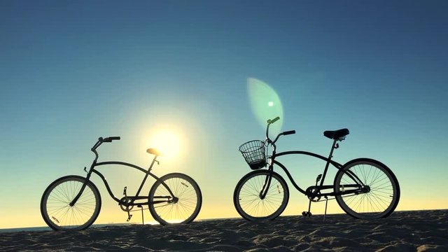Scenic sunrise beach with atmospheric lens flare hovering over two old-fashioned cruiser style bicycles standing in the sand