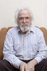 Old sick lonely man in the armchair at home