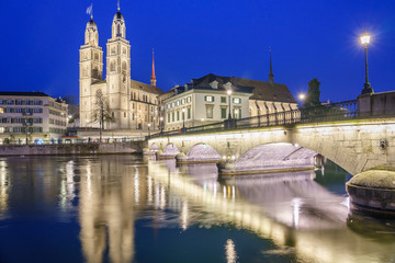 Fototapeta na wymiar Beautiful view of historic city center of Zurich with famous Grossmunster Church and Munsterbucke crossing river Limmat on Twilight time in summer, Canton of Zurich, Switzerland