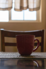 Lonely red mug on a table in rustic kitchen