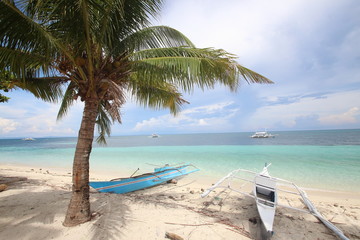 Fototapeta na wymiar Colorful wooden boats on a beautiful tropical island white sandy beach