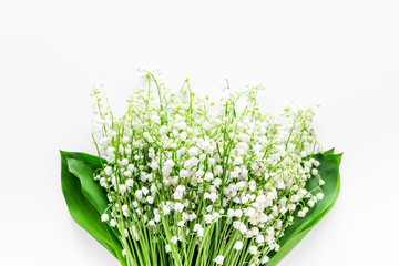 Small and fragrant spring flowers. Bouqet of lily of the valley flowers on white background top view copy space