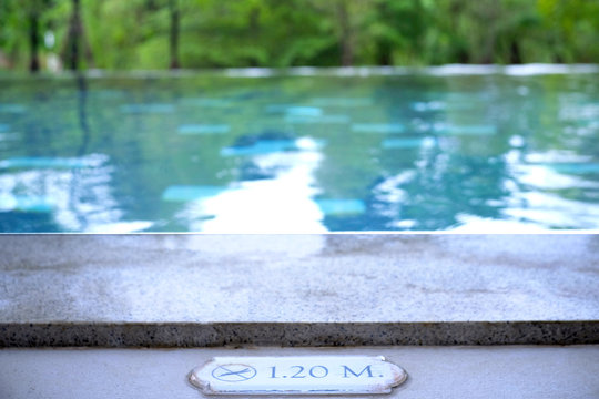 Selective focus caution and warning sign depth of swimming pool.