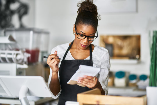 shop assistant taking order on notepad at restaurant counter