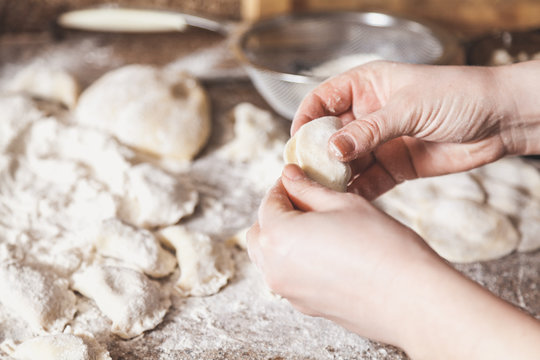 hands of woman make dumpling over granite table
