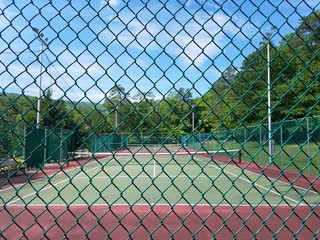 metal fence and green and red tennis court