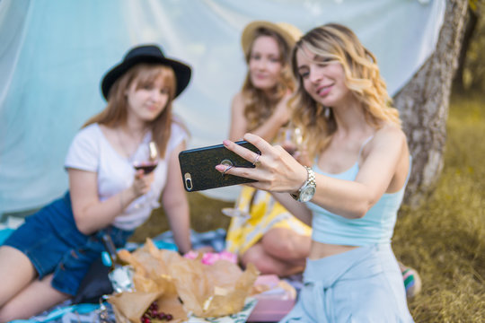 Group of girls friends making picnic outdoor. They make selfie photo from smartphone. bachelorette, party
