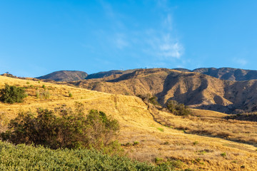 Southern California hillsides with dry grass covering hills after recent forest fires