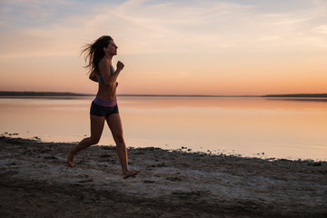 Fototapeta na wymiar Woman Running on the Beach at Sunset.