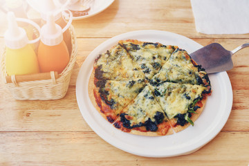 Slice of hot spinach pizza on table