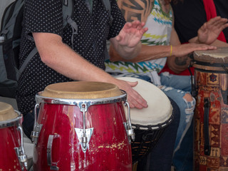 Man plays Mexican conga drums amongst others playing along