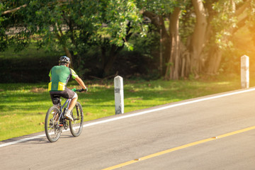 Cyclist in the park with orange sunlight scattered throughout
