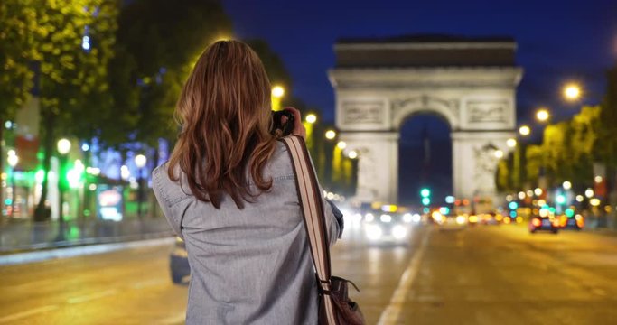 Rear view of travel photographer taking picture of Arc de Triomphe, Woman tourist photographing landmark in Paris, 4k